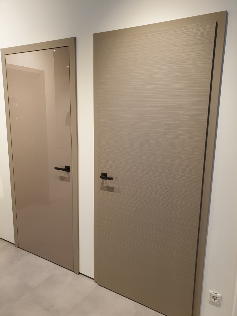 Слева межкомнатная дверь Херман с глянцевой поверхностью, цвет taupe, справа рифленая поверхность того же цвета